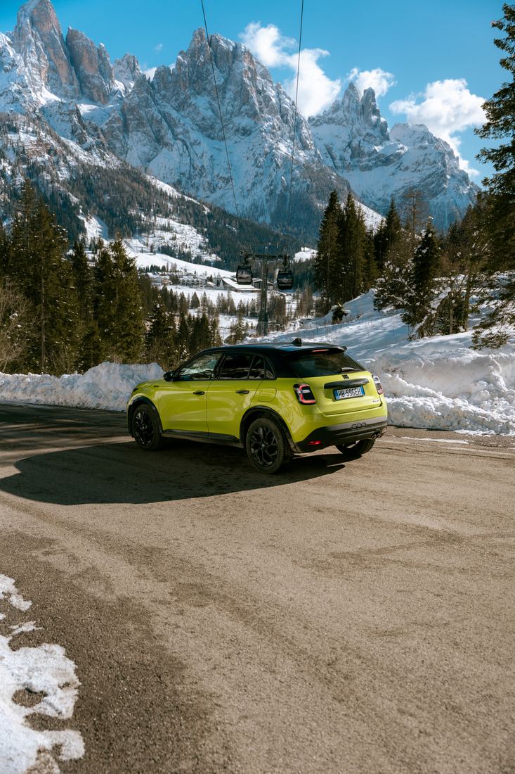 Auto gialla tra le montagne innevate